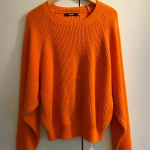 Orange stickad tröja från Bik Bok - Säljer en superfin orange stickad tröja från Bik Bok. Perfekt för höst och vinter med sin varma och mysiga känsla. Tröjan har långa ärmar och en rund halsringning. Den är i användskick och passar perfekt för att liva upp garderoben med lite färg!