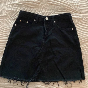 Svart jeanskjol - Säljer min svarta jeanskjol med slitningar då den är för liten för mig. Från HM i gott skick. I strl XS/34