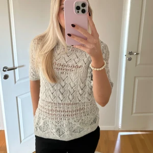 Vit stickad tröja - Säljer en superfin stickad tröja med korta ärmar från Zara. Den har ett snyggt hålmönster som ger en luftig känsla. Tröjan är i bra skick och passar både till vardags och lite finare tillfällen. Perfekt att matcha med jeans eller kjol! 🌼