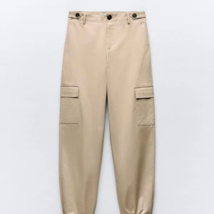 Beige cargopants - Säljer ett par snygga beige cargopants i mycket bra skick. De har en loose passform och är perfekta för både vardag och äventyr. Byxorna har praktiska fickor på sidorna och en bekväm midwaist. Perfekta för höst och vår! Dem är normal vida nertill. 