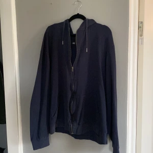 Mörkblå hoodie från 157 - Säljer en mörkblå hoodie från 157 i storlek XL. Den har en dragkedja framtill och en skön huva med snören. Perfekt för kyliga dagar och mysiga stunder. Använd men i bra skick!