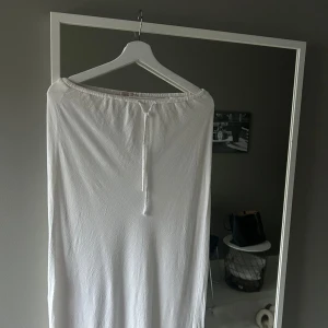 Vit lågmidjad långkjol  - Jag säljer denna vita långkjol från Nelly i linne material. Den är i storlek S men passar större med. Säljer då den inte kommer till användning och är för lång för mig som är 167 cm. Den har inga defekter, men skulle kunna ha en missfärgad kant. 