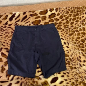Svarta shorts i bomull - Säljer ett par svarta shorts i 100% bomull. De har en klassisk stil med knapp och dragkedja framtill. Perfekta för sommaren och passar till både vardag och lite finare tillfällen. De är i storlek M och har en bekväm passform.(det var en vatten droppa bara)