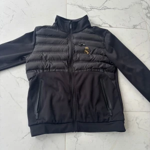 Real Madrid cardigan - En jättefin real Madrid cardigan för den som är ett fan. Har haft på mig den ett fåtal gånger då den var i fel storlek Pris kan diskuteras