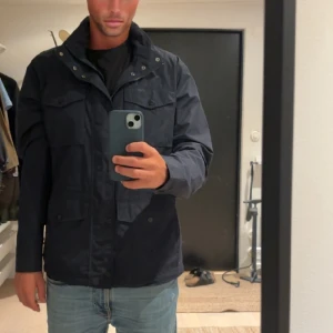 Field Jacka - Tja! Säljer nu en snygg field jacka från Bondelid. Själva kragen går att väckla ut till luva ifall de behövs. Modellen på bilden är ca 185. Jackan bör sitta bra ifall man är runt 180-190 cm. Jackan är väldigt sparsamt använda och i toppskick!