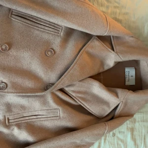 Gammelrosa kappa - Kappa från Stradivarius, köpt för 600kr. Använd i höstas, några små fläckar, har inte provat tvätta bort. Lappen sitter lite löst, annars i bra skick!