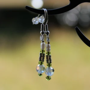 Handgjorda örhängen med pärlor och gröna detaljer - Säljer ett par superfina handgjorda örhängen med pärlor och gröna detaljer. De har en mix av vita och gröna pärlor samt några glittriga pärlor som ger en extra touch. Perfekta för att piffa upp vilken outfit som helst! 💚✨