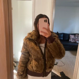 Brun pälsjacka med dragkedja - Säljer en supermysig brun pälsjacka i storlek M. Jackan har en dragkedja framtill och ribbade muddar vid ärmslut och nederkant. Perfekt för höst och vinter❤️