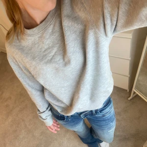 Grå sweatshirt - Säljer en grå sweatshirt i storlek XS. Den är superbekväm och perfekt för vardagsbruk. Tröjan har långa ärmar och är gjord av mjukt bomullsmaterial. Den har en liten reva på sidan av armen, men annars i bra skick. Perfekt för höst och vinter! 🩶
