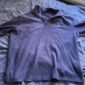 Mörkblå tröja från Polo Ralph Lauren - Säljer en snygg mörkblå tröja från Polo Ralph Lauren. Tröjan är i storlek M och är tillverkad av 100% bomull. Den har en dragkedja vid halsen och en broderad logga på bröstet. Perfekt för höst och vinter! 🧥