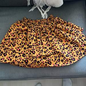 Säljer en superfin leopardmönstrad kortkjol. Den är perfekt för både vardag och fest! Kjolen har en elastisk midja som gör den bekväm att bära och den har en volangdetalj som ger den lite extra stil. Materialet känns lätt och luftigt, vilket gör den perfekt för varmare dagar.