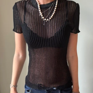 Svart transparent topp - Jätte cool topp med ribbad och tajt passform. dessvärre har den ett hål på sidan av armen💕