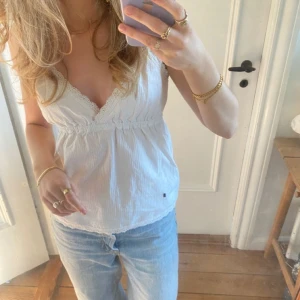 Brandy Melville  - En jättefin vit topp från brandy Melville med spets detaljer. Den är har knappt kommit till användning och ser som ny ut. 