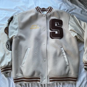 Varsityjacka - Lite missfärgad rosa vid på ena ärmen men annars i bra skick. Säljer då det är fel storlek för mig.