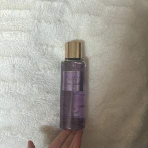 Säljer en Victoria's Secret Love Spell body mist. Den kommer i en genomskinlig lila flaska med en guldig kork. Doften är en blandning av körsbärsblom och färsk persika, vilket ger en fräsch och söt doft. Den är aldrig använd. Perfekt för daglig användning eller som en present! 💜