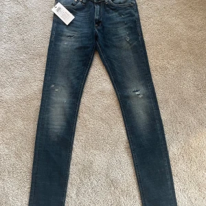 Mörkblå  jeans från Jack & Jones - Säljer ett par snygga mörkblå jeans från Jack & Jones. De har en cool slitningseffekt och är i nyskick, aldrig använda. Perfekta för både vardag och fest! Passar bra med en t-shirt eller en snygg skjorta. Storlek 29/32 nypris 800kr