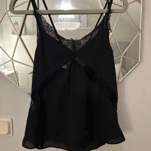 Svart topp ifrån Bik Bok - Säljer denna jätte snygga topp ifrån Bik Bok i storlek XS. Den har fina spets detaljer och är en perfekt festtopp🥰den är oanvänd