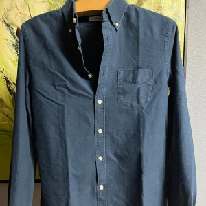 Mörkblå skjorta från Lindbergh - Säljer en stilren mörkblå skjorta från Lindbergh. Skjortan har långa ärmar och en klassisk krage med knappar. Perfekt för både vardag och fest! 🕺