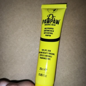 Dr. PAWPAW Original Balm - En mångsidig och lugnande balm med naturlig pawpaw. Perfekt för läppar, hud och nagelband. Den är doftfri och kan användas för att återfukta torr och irriterad hud. Innehåller ingredienser som olivolja och aloe vera.