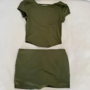 Set - Militärgrönt sett, tröjan är öppen i ryggen och kjolen har shorts inbyggt! 