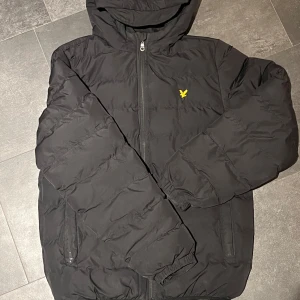 Lyle & Scott dunjacka - Hej, säljer denna Lyle & Scott jacka på grund av att den är för liten för mig, den är i bra skick och perfekt nu till vintern. Storlek är 14-15 years of age vilket motsvarar ca 164-170 cm.
