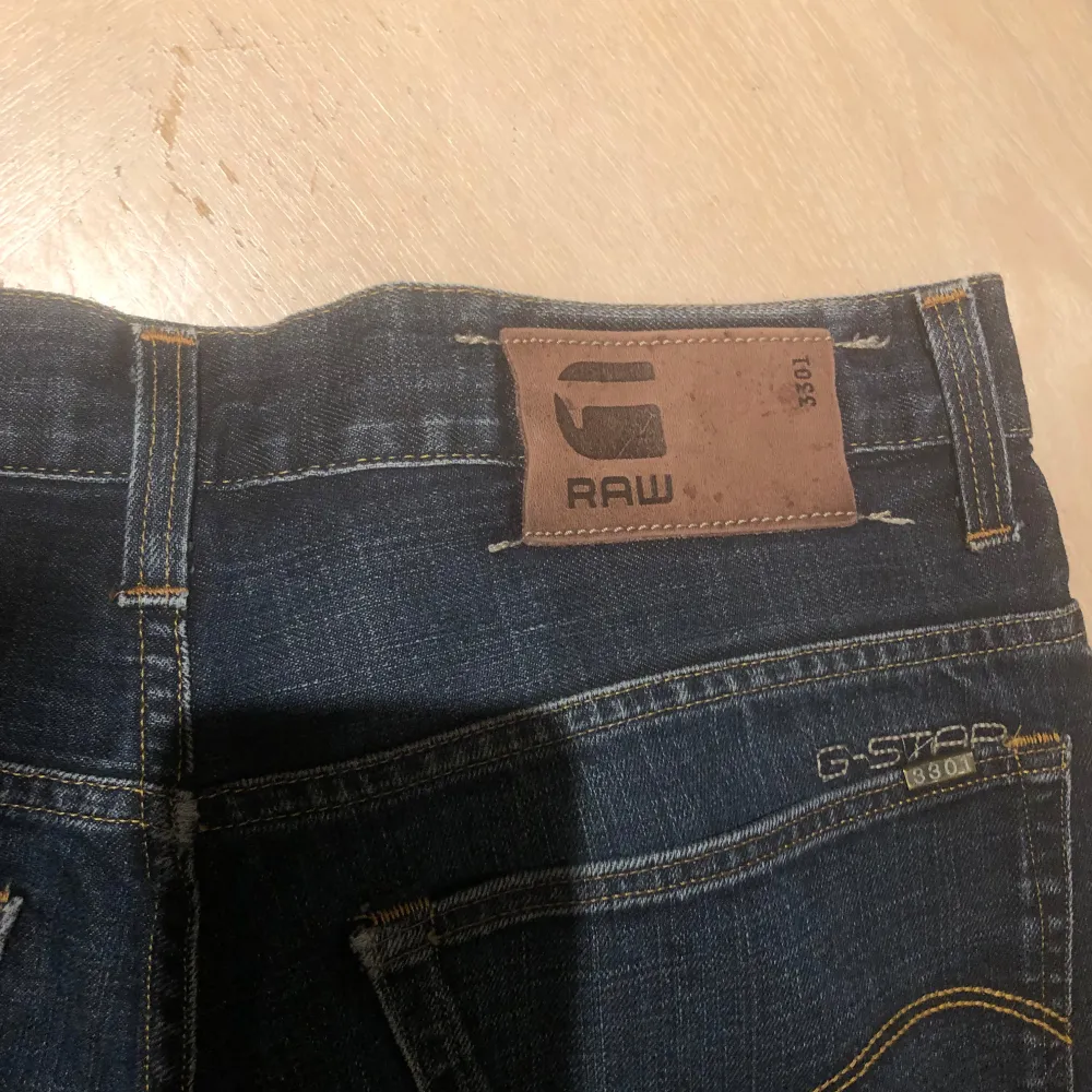 Säljer ett par snygga mörkblå jeans från G-Star RAW. De har en klassisk femficksdesign och knappar i gylfen. Perfekta för både vardag och fest! 🕺. Jeans & Byxor.