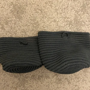 Svart stickad korg från IKEA - Säljer två mörkblå stickad korg från IKEA, perfekt för förvaring av småsaker. Den är tillverkad av 100% polypropylen och har en stilren design. Korgen är i mycket bra skick och passar bra i alla rum. Perfekt för att hålla ordning och reda!