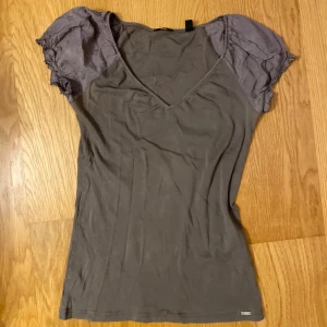 Brun topp från Esprit - Säljer en brun topp från Esprit. Den har en v-ringad design och korta ärmar med volangdetaljer. Köpt endast med bundle!!🎀