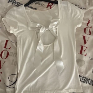 Vit t-shirt med rosett🤍🎀 - Superfin topp med rosett🎀🎀jag är inte säker att jag vill sälja så kom med bud!