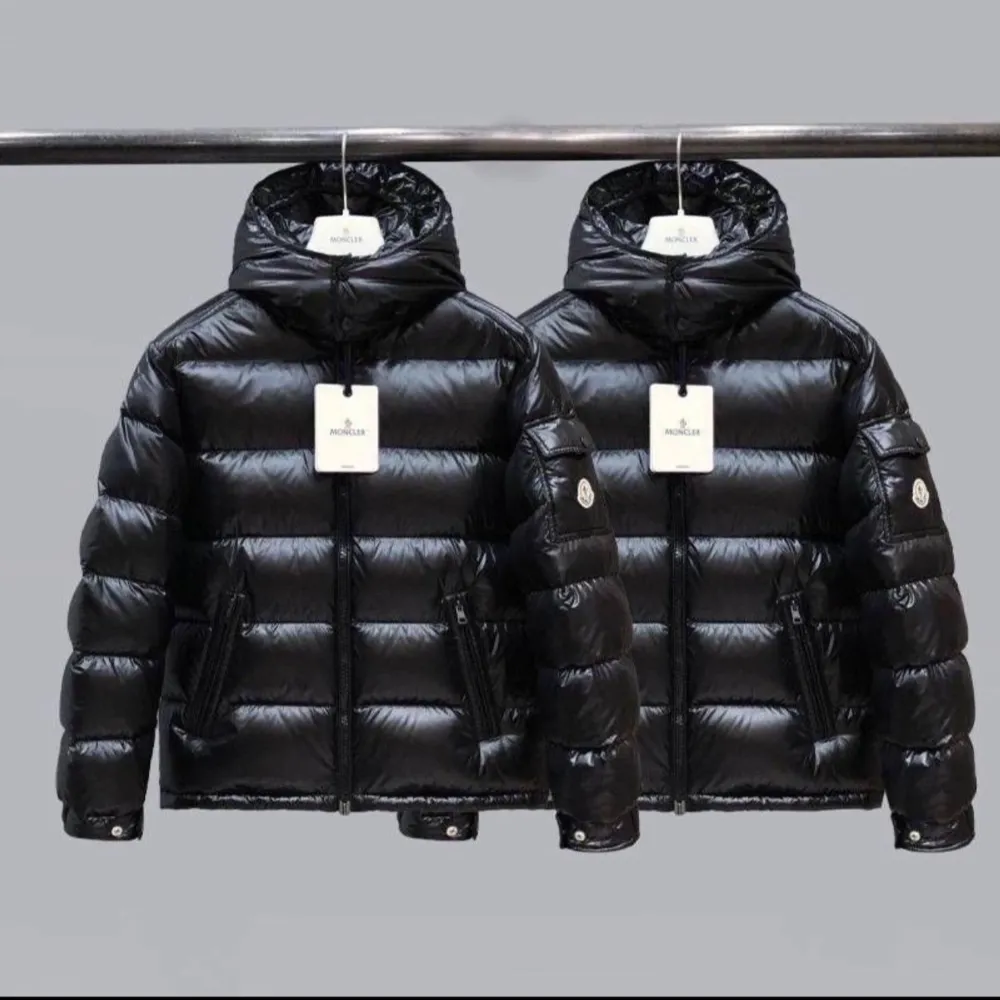 Säljer en snygg svart dunjacka från Moncler. Den är perfekt för vintern med sitt pufferdesign och har en praktisk huva. Jackan har dragkedja och knappar framtill samt två fickor med dragkedja. Den är i mycket bra skick och redo för kalla dagar.. Jackor.