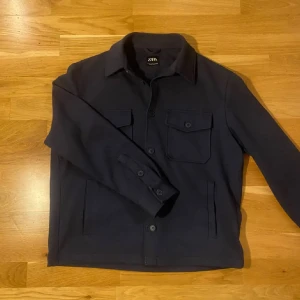 Mörkblå overshirt från Zara - Säljer en stilren mörkblå overshirt från Zara i mycket bra skick. Säljer för att den ej kommer till användning. 