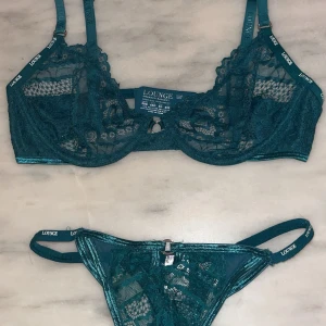 Grön spets-bh från Lounge - Spets-bh och trosor från Lounge i storlek 65D (passar 70C). Modell ”Charmed Balcony” färg ”Tukos”. Trosa i storlek XS. Den har justerbara axelband och spetsdesign med en liten ringdetalj framtill. Nypris:650kr.