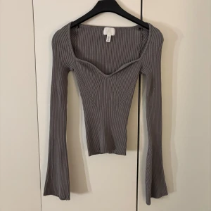 Långärmad topp - En grå figurnära topp från H&M i stolek xs. Utsvängda ärmar och superfin urringning. Superbra skick.