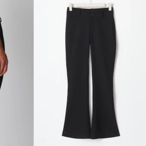 Svarta bootcut byxor - Snygga svarta bootcut byxor i mycket bra skick. De har en hög midja och är perfekta för både vardag och fest. Byxorna har knappar fram och fickor bak, vilket ger en stilren look. Passformen är tight upptill och vidgar sig vid benen för en klassisk bootcut-stil.