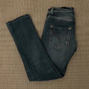 Mörkblå dondup Jeans - Säljer ett par snygga mörkblå dondup jeans i bra skick. De har en slim passform och är perfekta för både vardag och fest. Jeansen har en klassisk femficksdesign och är tillverkade i ett slitstarkt denimtyg. Perfekta för höst och vår!
