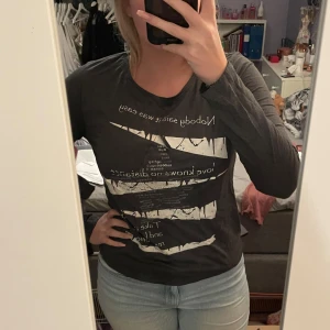 Mörkgrå tröja med tryck - Säljer en mörkgrå tröja med ett vitt tryck på framsidan. Perfekt för en avslappnad stil och passar bra till jeans. Tröjan är i bra skick då den knappt är använd. Perfekt för höst och vår! Köparen står för frakten💖