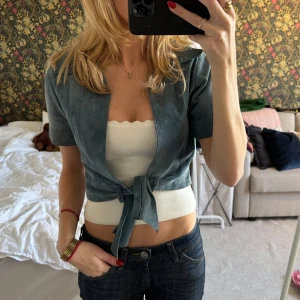 Blå kortärmad retro jacka i mocka  - Säljer en snygg blå kortärmad jacka med knyt framtill. Perfekt för vår och sommar! Den har en croppad stil som passar bra till både jeans och kjol. Använd endast en gång 💕