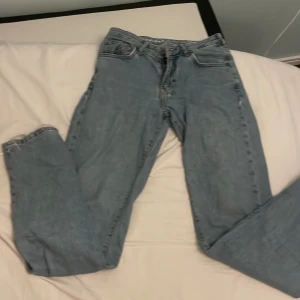 Blå jeans - Säljer ett par klassiska blå jeans i bra skick. De har en straight passform och är perfekta för vardagsbruk. Jeansen har en traditionell femficksdesign och är tillverkade i ett slitstarkt denimtyg. Perfekta för både höst och vår!