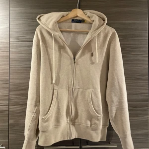 Beige hoodie från Polo Ralph Lauren - Säljer en fet beige hoodie från Ralph Lauren i mycket bra skick. Perfekt för både höst och vår, med en skön passform. Tröjan är i S, pris kan diskuteras vid snabb affär. Kolla in profilen och tveka inte att höra av er