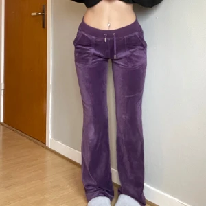 Lila mjukisbyxor från Juicy Couture - Säljer ett par lila mjukisbyxor från Juicy Couture i storlek S. Byxorna är supermjuka och har en bekväm passform med dragsko i midjan. De har en liten reva på ena benet, men annars i bra skick. Perfekta för mysiga dagar hemma! 💜nypris 1200kr