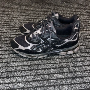  Asics gel nyc - Säljer ett par snygga och bekväma Asics gel nyc i svart och grått. Perfekta för träning eller vardagsbruk. De har en robust sula och klassisk snörning för bra passform. Använda men i bra skick.