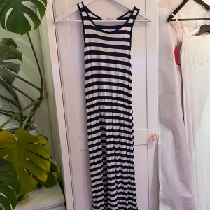 Blå-vitrandig långklänning - En långklänning med mörkblå och vita ränder från H&M. Den är i barnstorlek, men skulle säga att den passar XS/S. Den har en liten defekt då det är ett litet hål där det tidigare har suttit en fjäril. 🦋