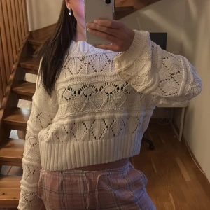 Vit stickad tröja - Säljer en superfin vit stickad tröja med ett gulligt hjärtmönster. Tröjan är croppad och har långa ärmar med ribbade muddar. Perfekt för höst och vår när du vill vara både varm och stilren. Passar perfekt till både jeans och kjol! Defekt!!! Bild 2 men med tanke på att tröjan är väldigt stor och så så ser man inte. Exempel bild 3 