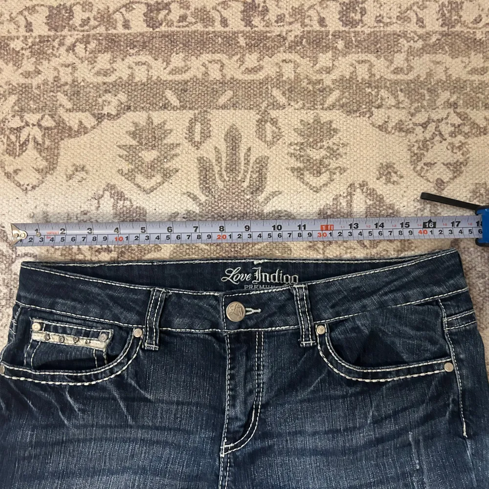 Säljer ett par snygga vintage mörkblå jeans från Love Indigo. De har coola broderade detaljer på bakfickorna som verkligen sticker ut. Jeansen har en klassisk femficksdesign och är i bra skick. Storlek 38! Använd köp nu funktionen ❤️. Jeans & Byxor.