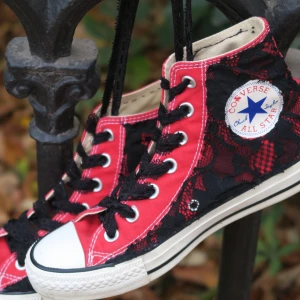 Röda Converse All Star med spetsdetaljer - Snygga röda Converse All Star sneakers med svart spetsmönster över hela skon. 