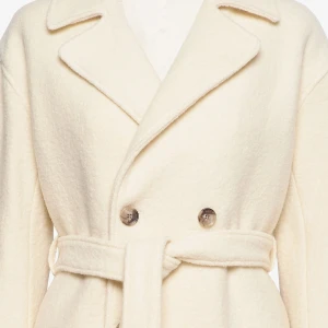 Vit kappa med bälte - Säljer en superfin vit Filippa K kappa i merinoull med knappar och bälte i midjan. Den har en klassisk design med långa ärmar och en snygg omlott-stil. Passar både till vardags och fest. Nypris 4400kr Lånad bild från hemsidan. 