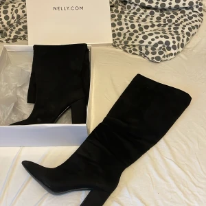 Svarta knähöga stövlar från Nelly - Snygga svarta knähöga stövlar från Nelly. Perfekta för hösten och vinter🤍. De är i nytt skick och passar perfekt för både vardag och fest. Superbekväma stövlar som man kan gå i en hel kväll, endast använda 1 gång.😍