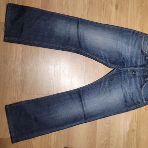 Blå jeans från Lee - Säljer ett par snygga blå jeans från Lee i bra skick. De har en klassisk straight fit och är perfekta för vardagsbruk. Jeansen har en snygg tvättad look och är tillverkade i slitstarkt denim. Perfekta för både höst och vår!