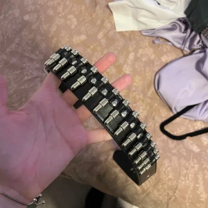 Bälte med patroner - Säljer ett coolt svart bälte med massor av patroner som ger en edgy look. Perfekt för att piffa upp en enkel outfit. Bältet är i bra skick och passar perfekt till både vardag och fest. Justerbar storlek för bästa passform.