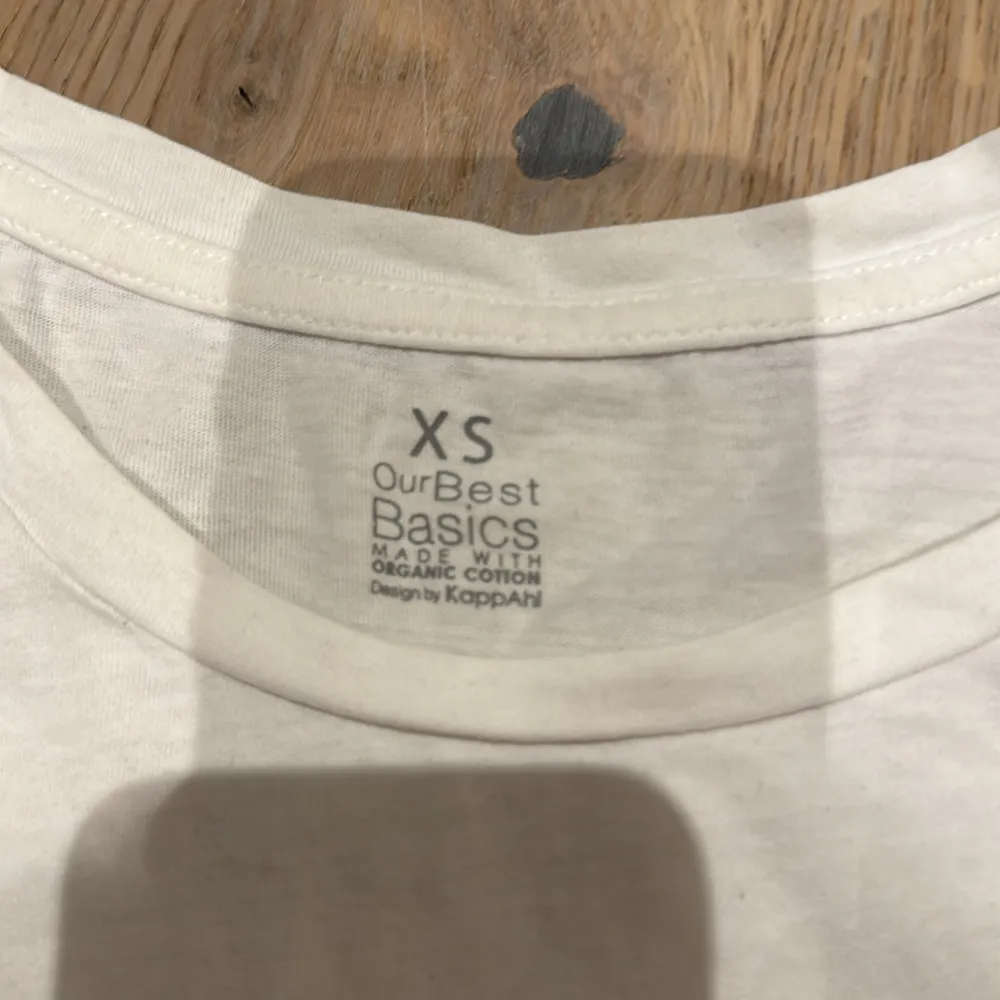 Säljer en vit t-shirt från Kappahl i storlek XS. Den är gjord av ekologisk bomull och har en klassisk design med korta ärmar. Perfekt basplagg för alla tillfällen!. T-shirts.